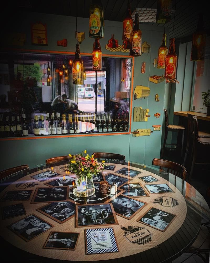 Bord med bilder av kjente sarpinger under glassplate. Foto.